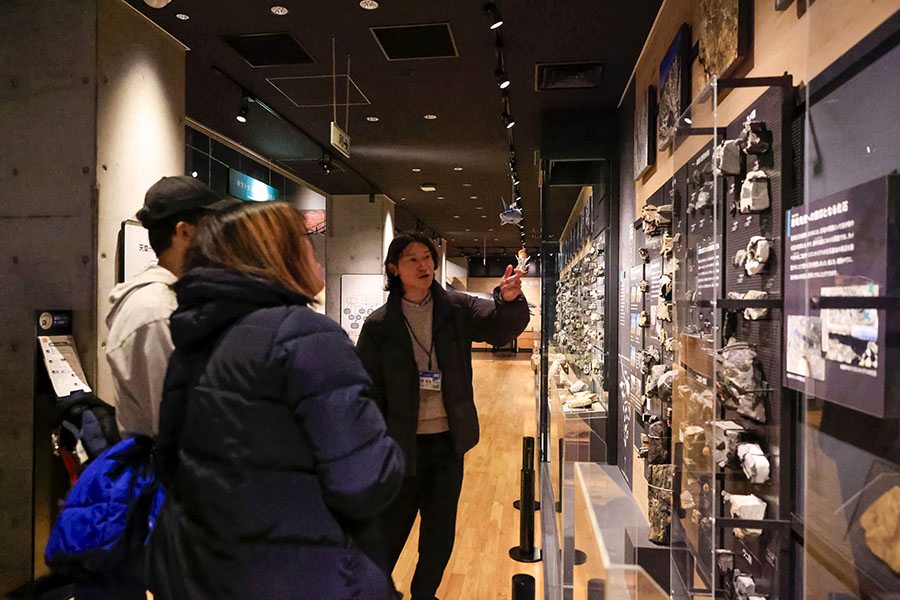 博物館の展示室でガイドの説明を聞く参加者